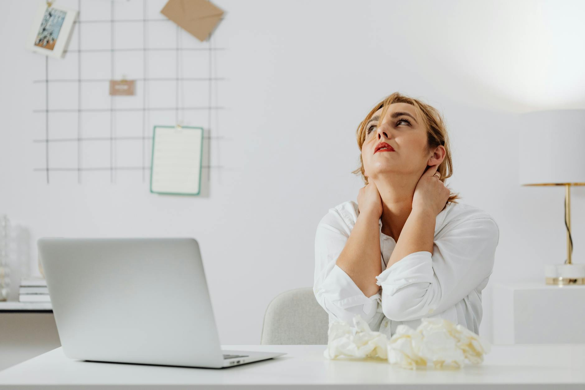 woman in white long sleeve shirt sitting at a table looking up